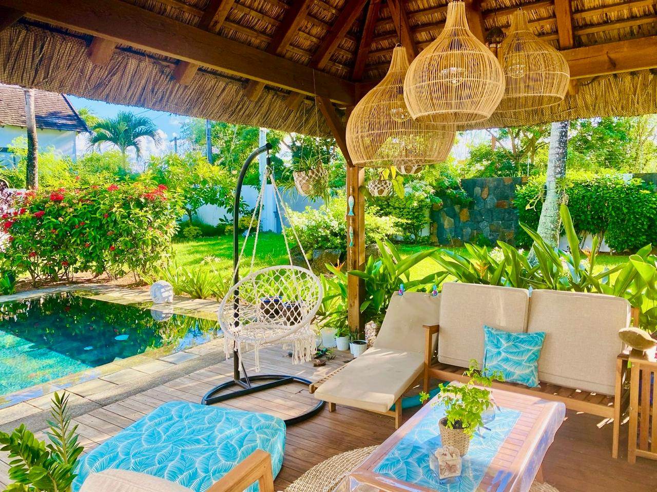 Shaded lounge under a thatched roof next to the pool